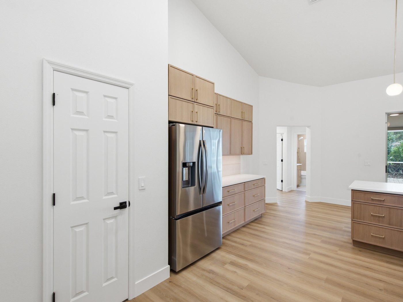 Full-height oak cabinets running to the ceiling, with a paneled refrigerator built into the run.